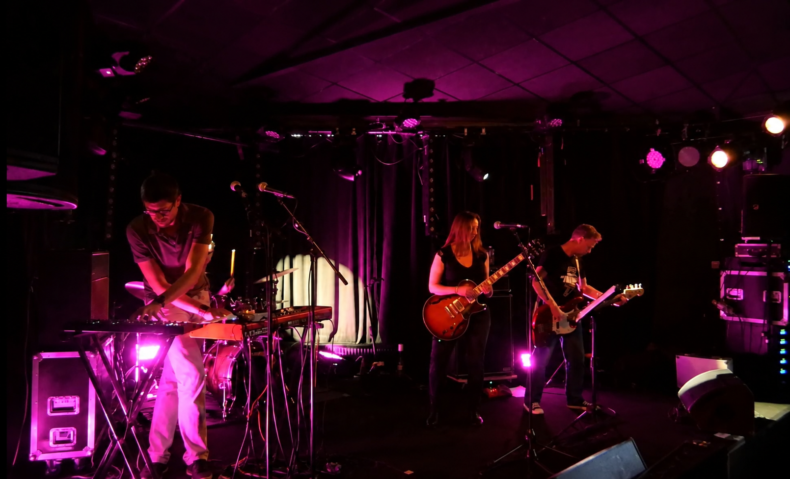 The Lambda sur scène sous des lumières magenta